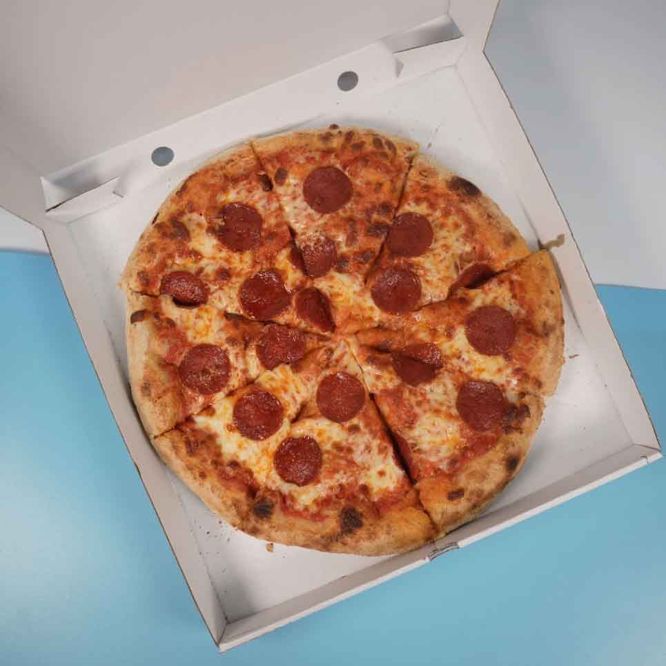 A full pepperoni pizza with melted cheese and a thick crust, sliced. 